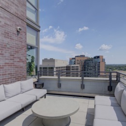 Access to resident-only features rooftop patio and pool with a building behind it