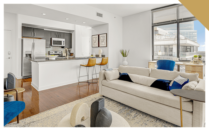 living room with a couch windows and view of a kitchen